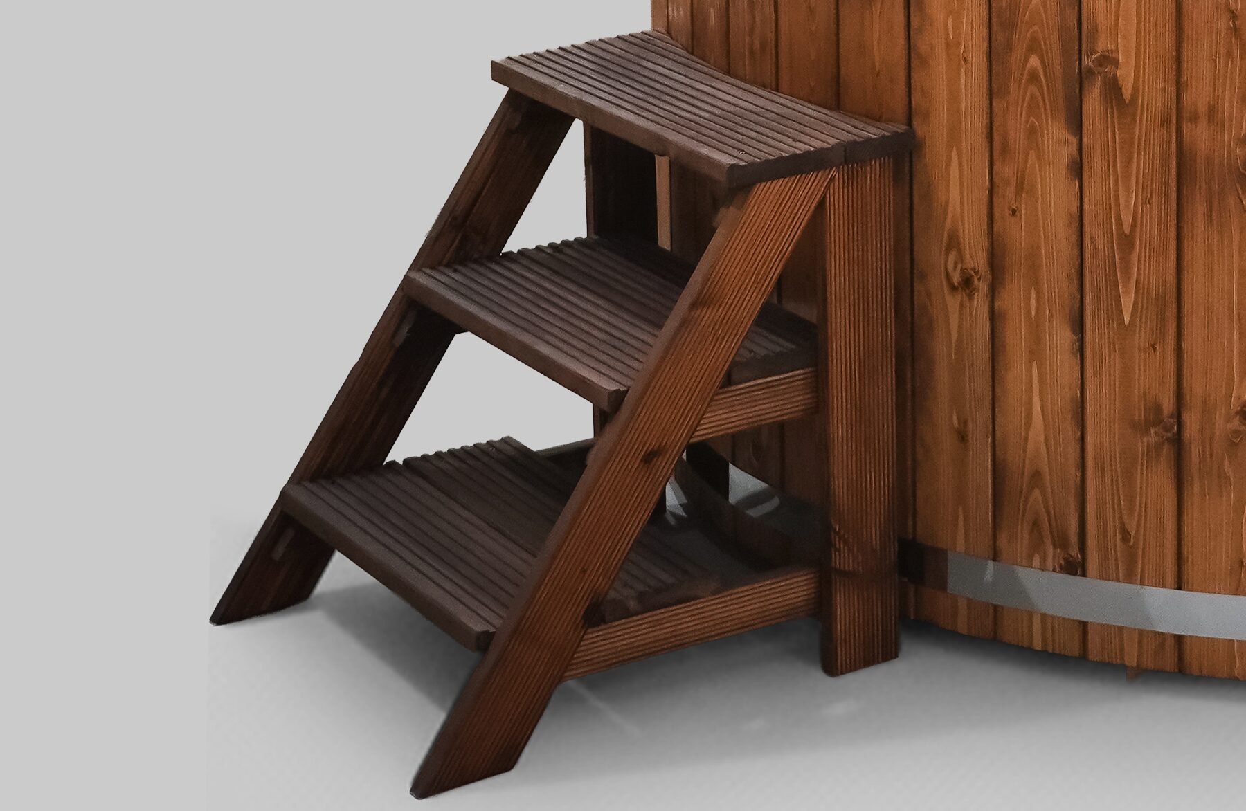 Wooden entry steps with three treads, made of dark wood, positioned beside a Makoya Spa hot tub SOPHIA.