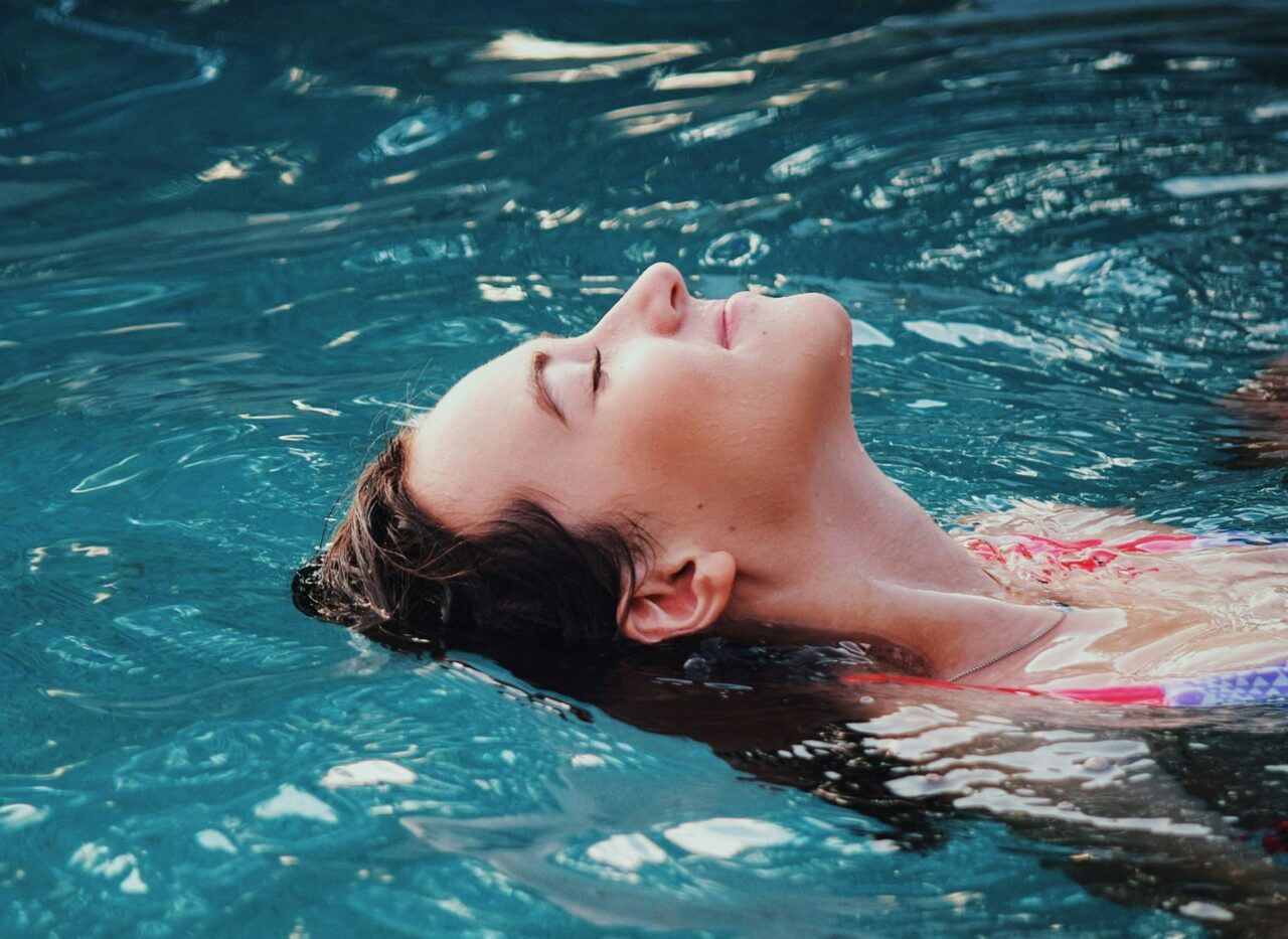 Person floating relaxedly on their back in the warm water of a hot tub
