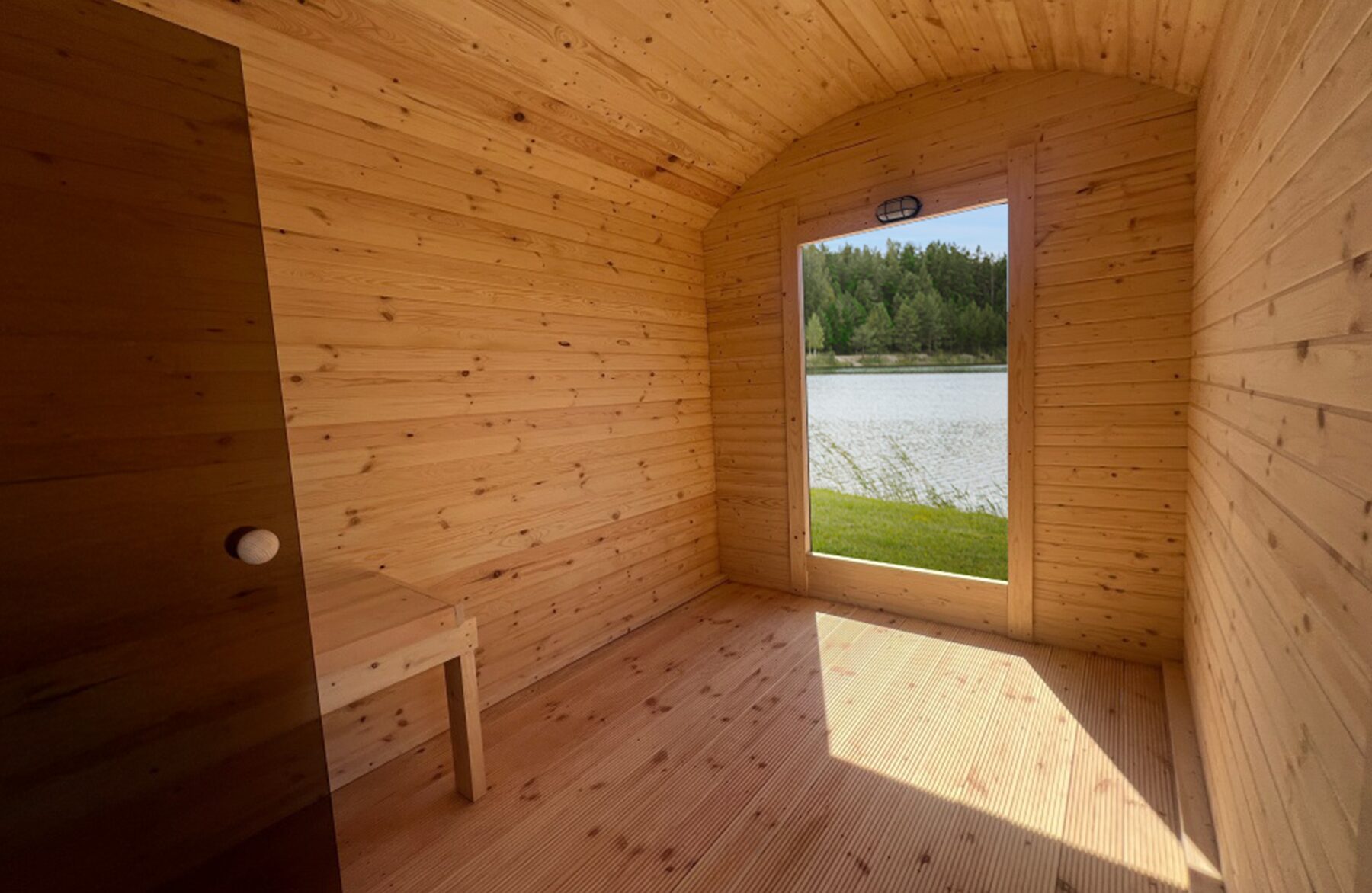 Interior view of the Makoya Spa sauna CERES featuring light wooden cladding, an integrated bench and glass door.
