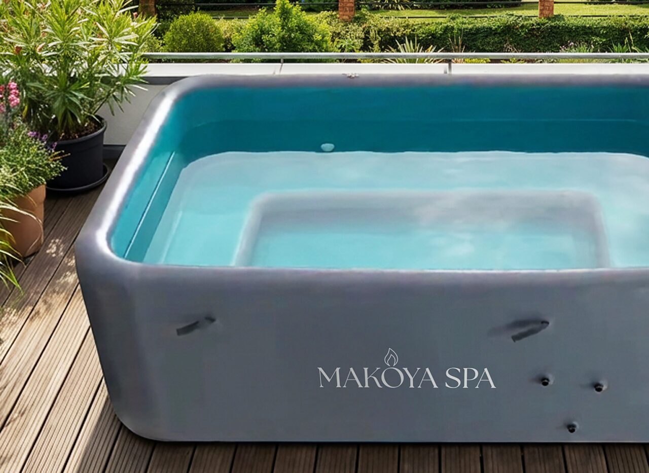 Close-up of a modern Makoya Spa Hot Tub Pool on a stylish wooden terrace, nestled in a green garden landscape